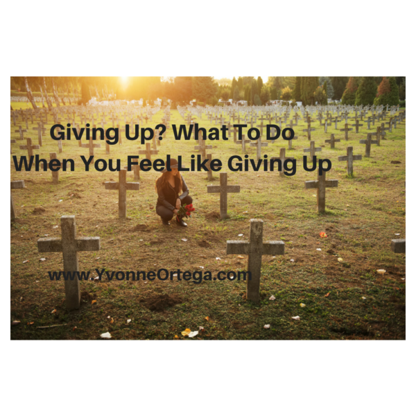 Grieving woman giving up at the cemetery surrounded by lots of crosses at grave sites